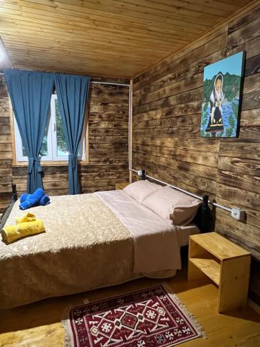 1 dormitorio con 1 cama y una pintura en la pared en Guesthouse Zgiboza, en Shkodër