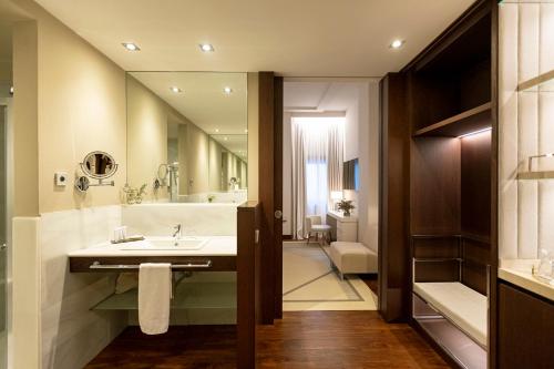 a bathroom with a sink and a large mirror at Hospes Amérigo, Alicante, a Member of Design Hotels in Alicante