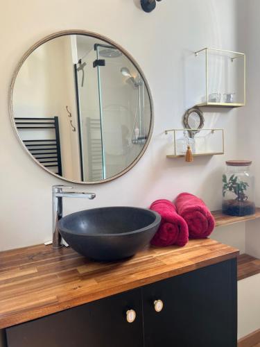 uma casa de banho com um lavatório preto e um espelho em Maison Chessy em Chessy