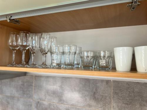 a row of glasses sitting on a shelf at CRISTAL Home Boutique Apartment 2 - Luminos, Confortabil, Practic, Zona Rezidentiala in Craiova