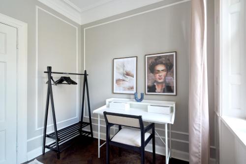 La salle de bains est pourvue d'un lavabo blanc et d'une chaise. dans l'établissement Stylish 4 Bedroom flat in CPH City, à Copenhague