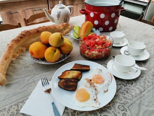 a table with a breakfast of eggs toast and fruit at EUROPEAN Backpackers Hostel in Tbilisi City