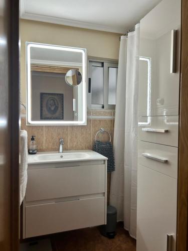 uma casa de banho com um lavatório e um espelho em HABITACIÓN DOBLE o TRIPLE CORAZON DE RUZAFA em Valência