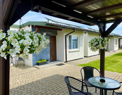 烏涅尤夫的住宿－Zielone Zacisze，庭院配有桌椅和白色鲜花。