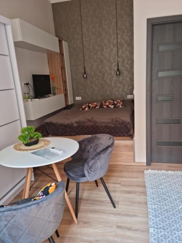 - un petit salon avec un lit, une table et une chaise dans l'établissement Glamour mini home, à Esztergom