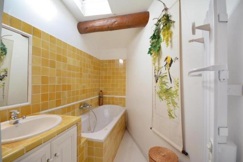 a bathroom with a sink and a tub and a toilet at Terrasses du château in Le Barroux