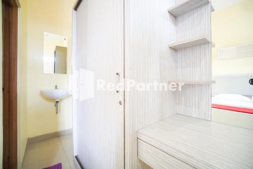 a small bathroom with a sink and a toilet at Indah Residence Syariah Mitra RedDoorz in Jakarta