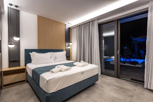1 dormitorio con 1 cama con 2 toallas en Nooa Villas, en Skala Rachoniou