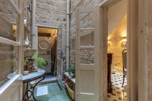 バレッタにあるStunning Valletta Palazzinoの開いたドアと植物が置かれたテーブルのある部屋