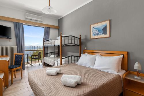 Schlafzimmer mit Etagenbett und Balkon in der Unterkunft Stefania Hotel in Amarinthos