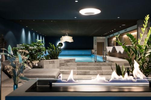 ein Wohnzimmer mit einem blauen Sofa und einigen Pflanzen in der Unterkunft Post Hotel - Tradition & Lifestyle Adults Only in Innichen