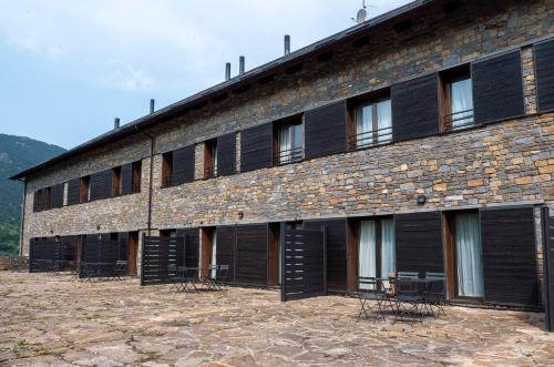 a building with black shutters on it at Aparthotel Siente Boí & SPA in Pla de l'Ermita