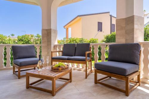 a patio with three chairs and a coffee table at Villa delle Lantane San Lorenzo Marzamemi in San Lorenzo