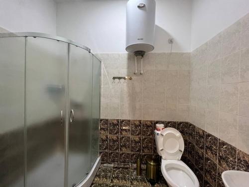 a bathroom with a toilet and a glass shower at Orom Hotel Fergana in Fergana