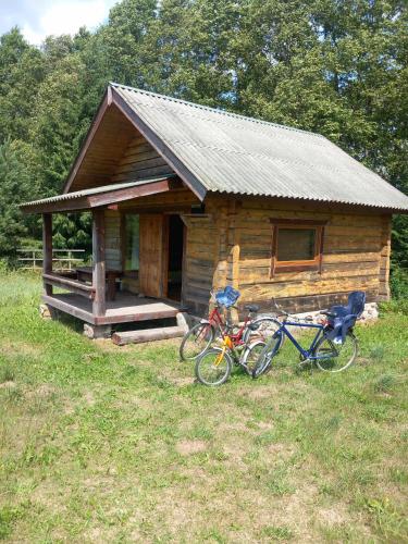 two bikes parked in front of a log cabin at Poilsis Dumblio telmologiniame draustinyje in Molėtai