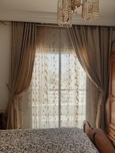 ein Schlafzimmer mit einem Bett und einem großen Fenster in der Unterkunft Appartement s+2 au plein coeur de sousse in Sousse