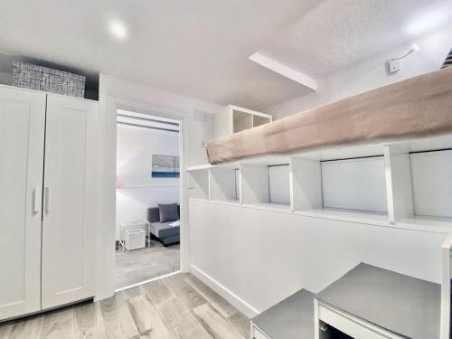 una sala de estar con paredes blancas y estanterías blancas en Charming Paseo de los Olmos - Estancias Temporales en Madrid