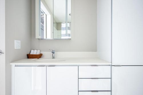 a white bathroom with a sink and a mirror at Loop 1BR w Gym Roof nr Millennium Park CHI-369 in Chicago