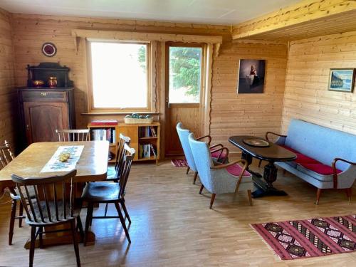 a living room with a table and chairs and a couch at Northern Light Cabin Lofoten in Sennesvik
