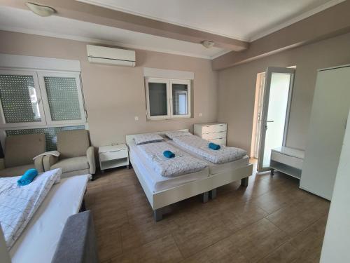 Un dormitorio con 2 camas y una silla. en Hacienda Kolenda en Mostar