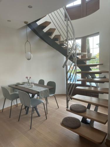 a dining room with a spiral staircase and a table and chairs at Royal King in Vrnjačka Banja