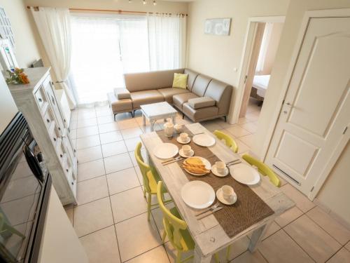 einen Esstisch und Stühle im Wohnzimmer in der Unterkunft Apartment Green Garden-8 by Interhome in De Haan