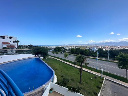 a swimming pool on top of a building with a street at Appart-Hotel cabo negro in Cabo Negro