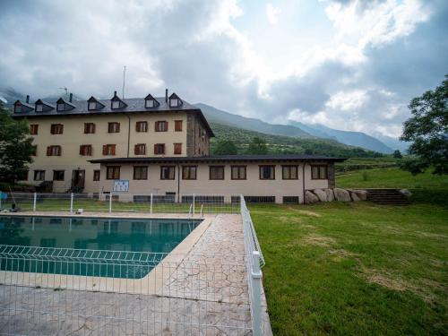 a large building with a swimming pool in front of it at Hotel Taüll in Pla de l'Ermita