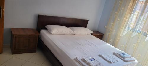 a small bedroom with a bed with a wooden headboard at Charming Apartment Lushnje in Lushnjë