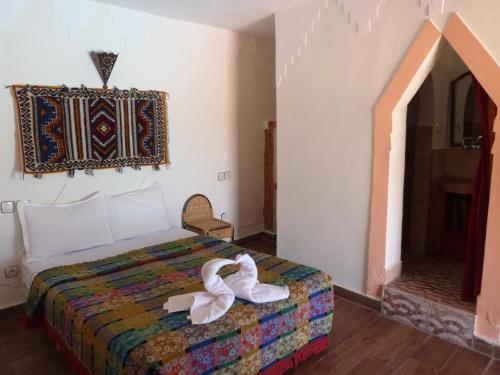 a bedroom with a bed with white shoes on it at La Kasbah du Jardin in Aït Ben Haddou