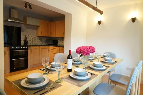 a dining room table with plates and wine glasses at Tranquil Retreat in Bicester in Bucknell