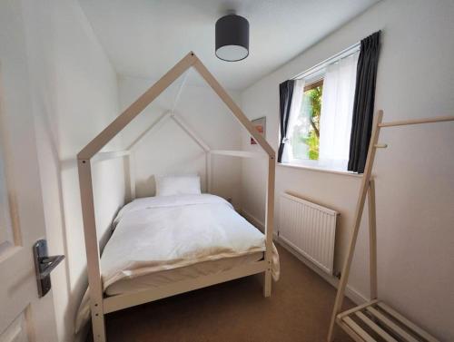 a bedroom with a canopy bed with a window at Tranquil Retreat in Bicester in Bucknell