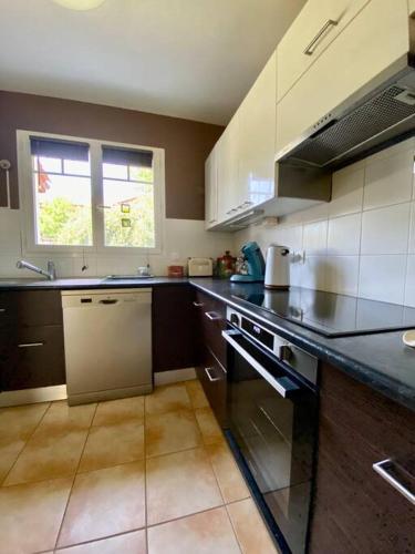 une cuisine avec un évier et une cuisinière four supérieur dans l'établissement Maison Familiale au pays basque, à Urrugne