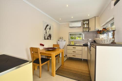 a kitchen with a wooden table and a dining room at Apartments Villa Graf in Smederevo