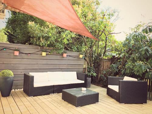 une terrasse avec un canapé blanc et une table dans l'établissement OHA CASES, à Audenge