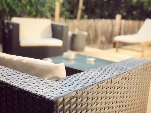 a wicker bench with a table and a chair at OHA CASES in Audenge