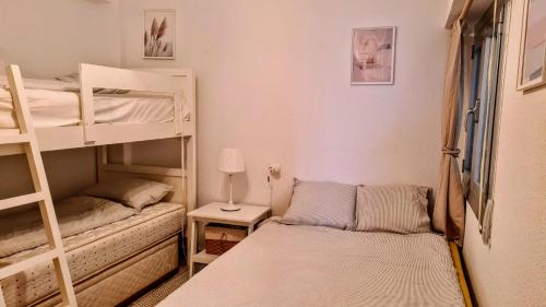 Kleines Zimmer mit Etagenbetten und einem Bett in der Unterkunft Apartmán pri mori in El Brosquil