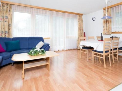 ein Wohnzimmer mit einem blauen Sofa und einem Tisch in der Unterkunft Apartment Amaryllis by Interhome in Saas-Grund