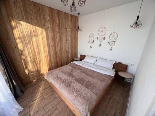 sypialnia z dużym łóżkiem i drewnianą podłogą w obiekcie Alma house - White w mieście Ałma-Ata