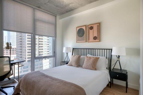 Una cama o camas en una habitación de W Loop 1BR w Deck Pool Gym 3 blocks to L CHI-645