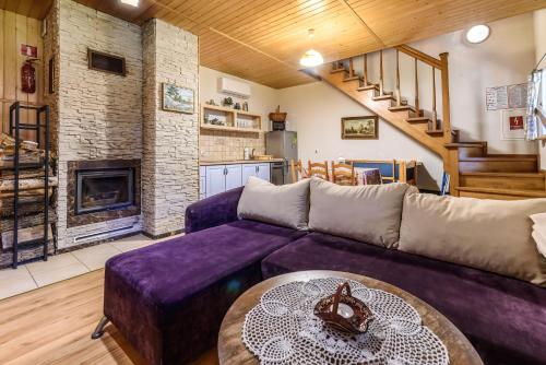 a living room with a purple couch and a table at Jasminowe Wzgorze in Wilkanów