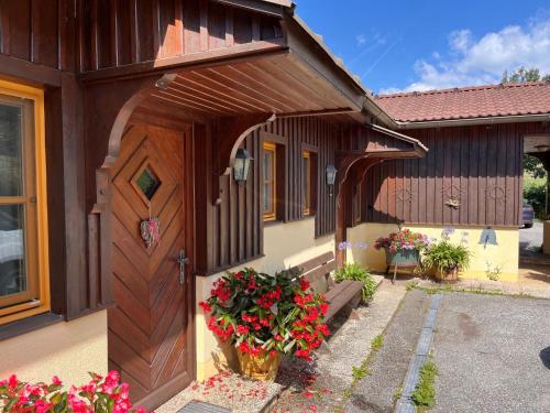 a house with a wooden door and some flowers at Apartment Kunzhof-3 by Interhome in Winklern