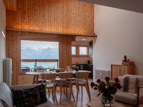 a dining room with a table and chairs and a window at Apartment Haut de Cry 16 by Interhome in Nendaz