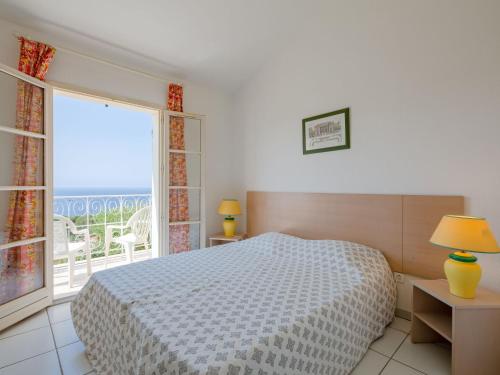 une chambre avec un lit et une grande fenêtre dans l'établissement Holiday Home Cap Estérel - Le Hameau - Mini Villa 35 by Interhome, à Saint-Raphaël