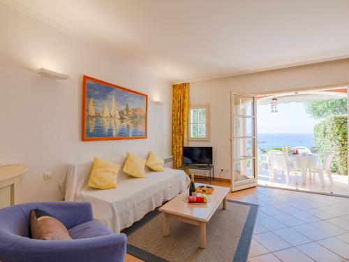 - un salon avec un lit et une vue sur l'océan dans l'établissement Holiday Home Cap Estérel - Le Hameau - Mini Villa 35 by Interhome, à Saint-Raphaël