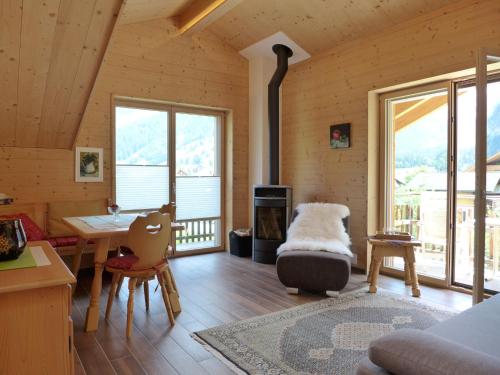 uma sala de estar com uma mesa e uma lareira em Apartment beim Ahorn by Interhome em Kandersteg