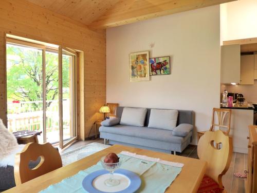 uma sala de estar com uma mesa e um sofá em Apartment beim Ahorn by Interhome em Kandersteg