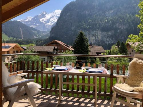 a table on a balcony with a view of a mountain at Apartment Beim Ahorn by Interhome in Kandersteg