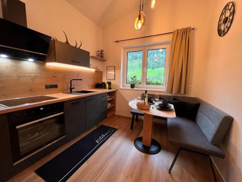 una pequeña cocina con una mesa y un sofá. en Apartment Apartement Haus Dankl by Interhome, en Fusch an der Glocknerstrasse