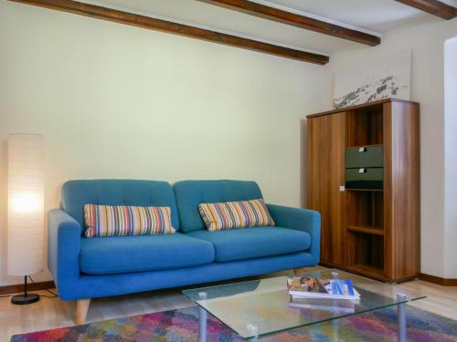 Sofá azul en la sala de estar con mesa de cristal en Holiday Home Ca' Virc by Interhome, en Olivone